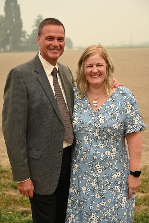 the author and her husband standing in front of field